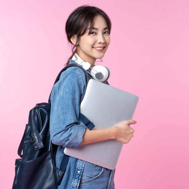 Portrait,Of,Smiling,Young,Asian,College,Student,With,Laptop,And